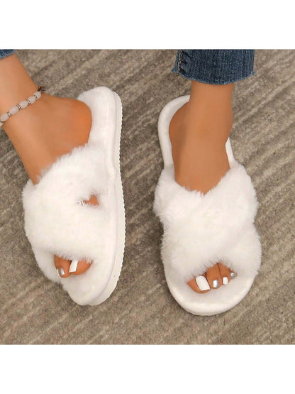 Close-up of white Axon Cloud-Soft cross strap fur slippers worn with denim jeans and a stylish anklet.